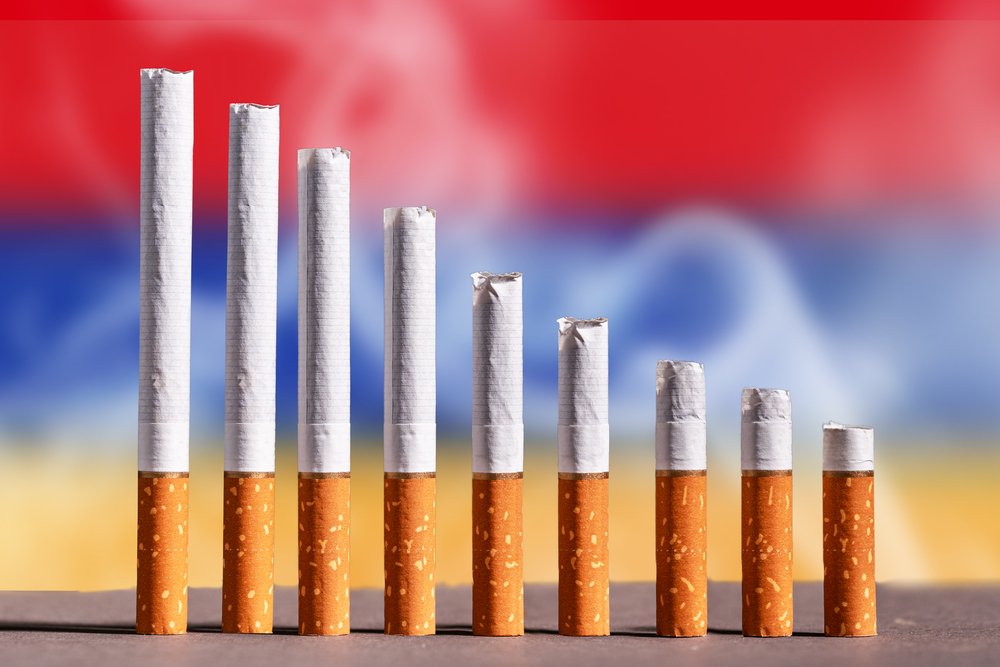 Some cigarettes placed vertically, in the background the flag of Armenia