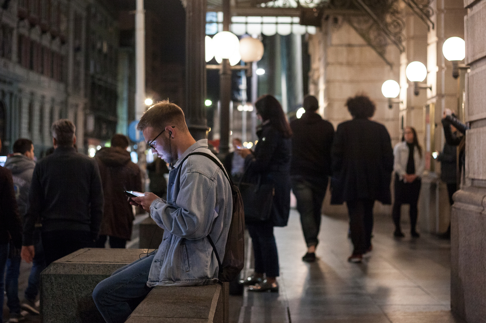 Young people in the center of Belgrade looking at their mobile