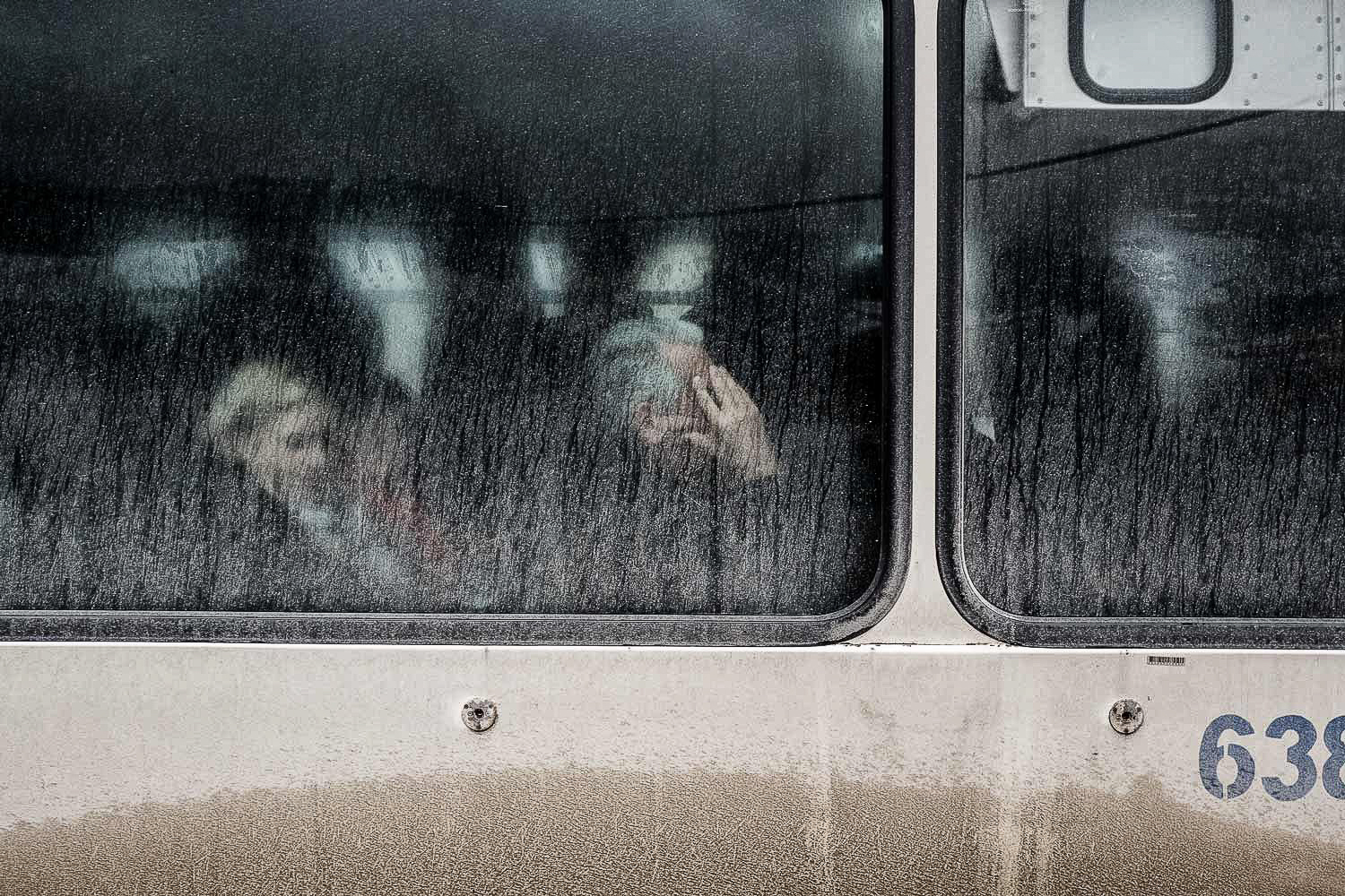 Passeggeri di un autobus di Sarajevo fotografati attraverso i vetri opachi in una giornata invernale