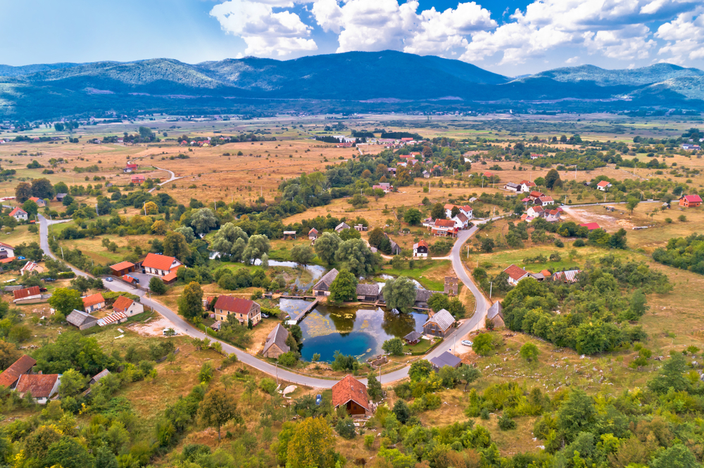 Veduta aerea di un villaggio nella regione della Lika, Croazia - @ xbrchx/Shutterstock Veduta aerea di un villaggio nella regione della Lika, Croazia - @ xbrchx/Shutterstock