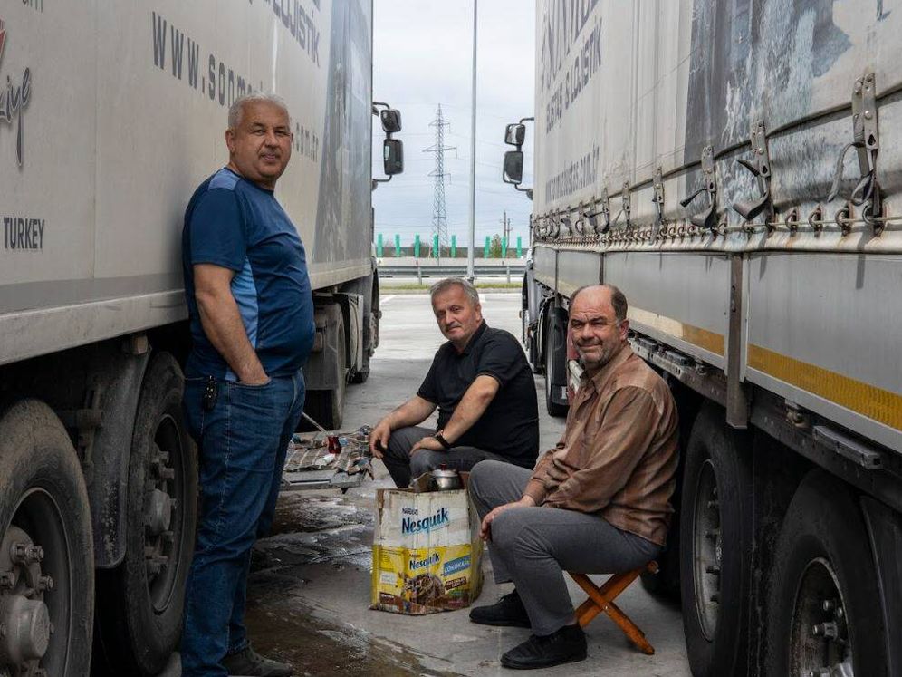 un gruppo di camionisti turchi si riposa all'ombra dei loro camion un gruppo di camionisti turchi si riposa all'ombra dei loro camion