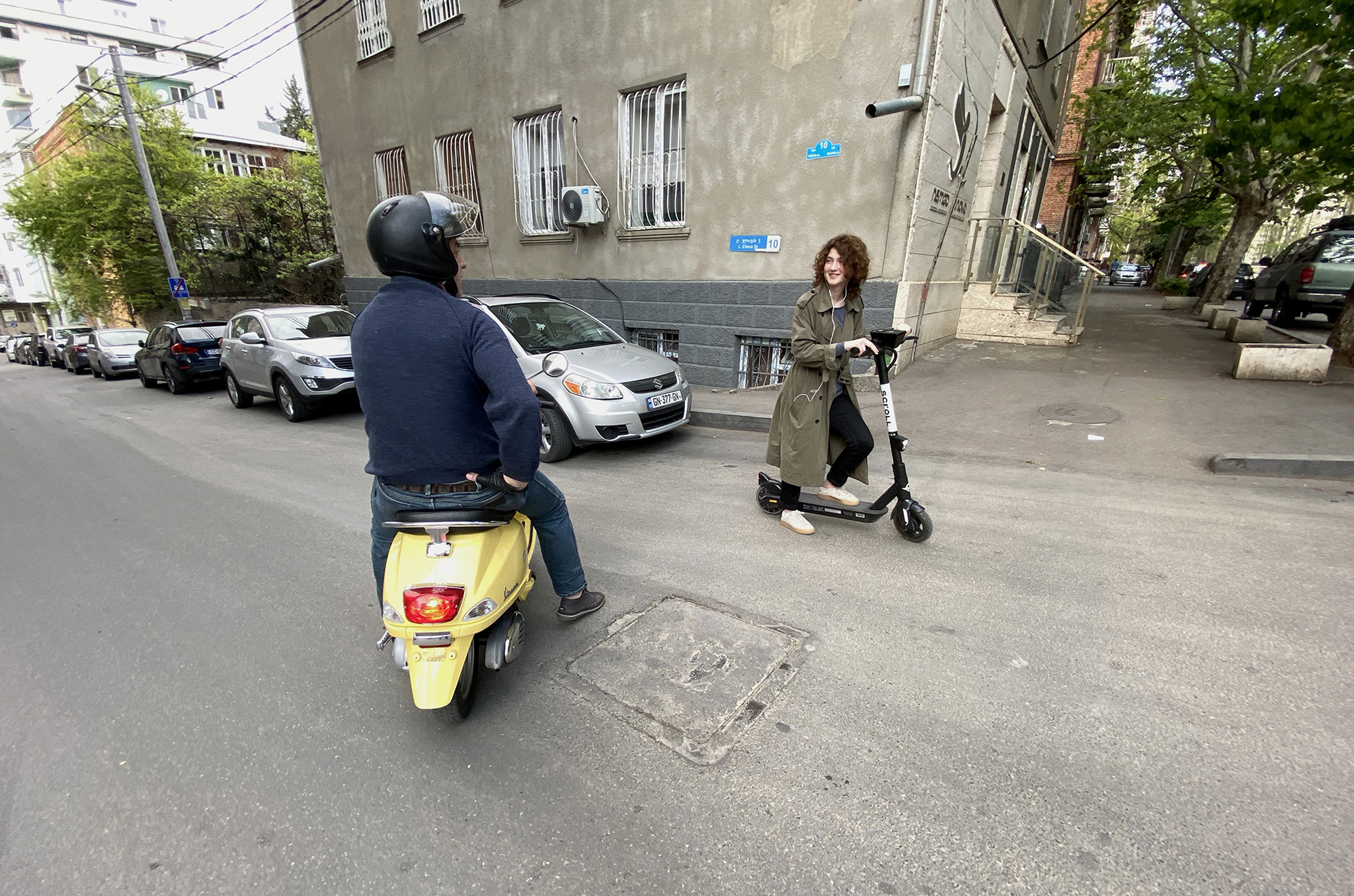 A motorised and electric scooter rider stop to chat at a crossroads during the COVID-19 state of emergency when most motorised transportation was prohibited in Tbilisi