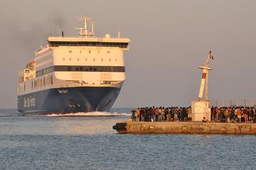 Migranti in attesa di un traghetto di linea che li porterà sul continente - foto F.Polacco