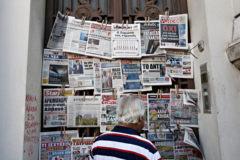 Un uomo legge giornali greci ad un'edicola © Alexandros Michailidis/Shutterstock