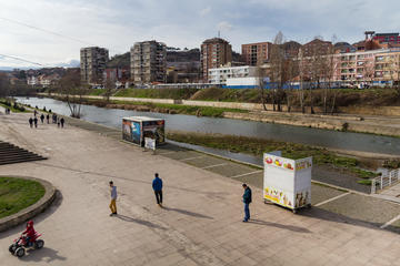 Mitrovica, persone passeggiano sulla riva nord del fiume Ibar © Giovanni Vale/Shutterstock