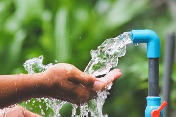 Rubietto con acqua che scorre e mano sotto l'acqua