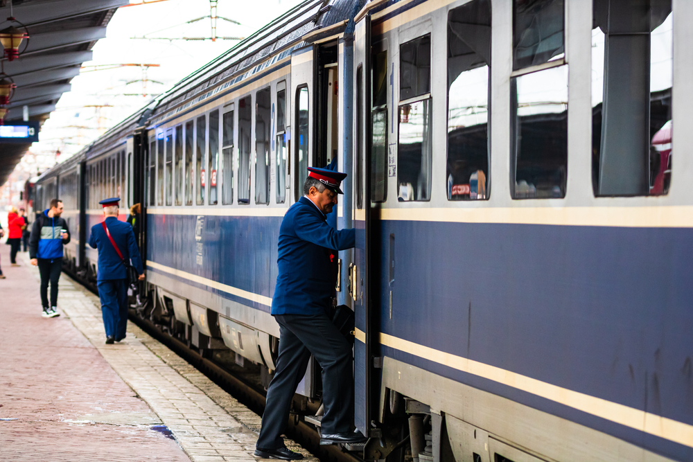 A railway worker gets on a train at a station in Bucharest, Romania