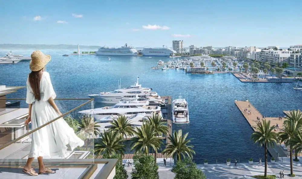 Una donna in primo piano e sullo sfondo gli edifici del progetto "Durrës Yachts & Marina"