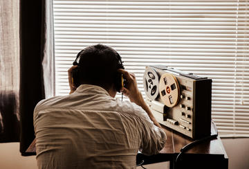 Un agente ascolta una conversazione registrata © Only_NewPhoto/Shutterstock