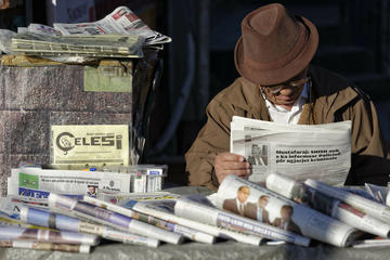Man reading a newspaper in Tirana Marcel Crozet CC BY-NC-ND 2.0 via Store norske leksikon