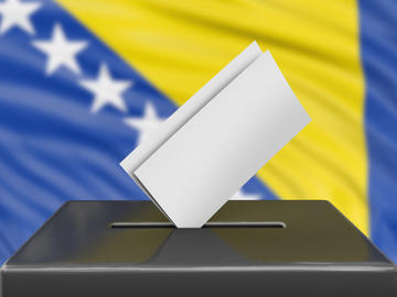 Urna elettorale con sfondo bandiera della Bosnia Erzegovina © corund/Shutterstoc