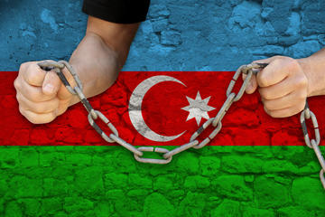 Uomo in catene, sullo sfondo la bandiera dell'Azerbaijan © Kittyfly/Shutterstock