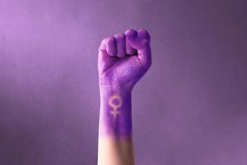 Pugno viola alzato di una donna per la giornata internazionale della donna e il movimento femminista  © AdriaVidal/Shutterstock