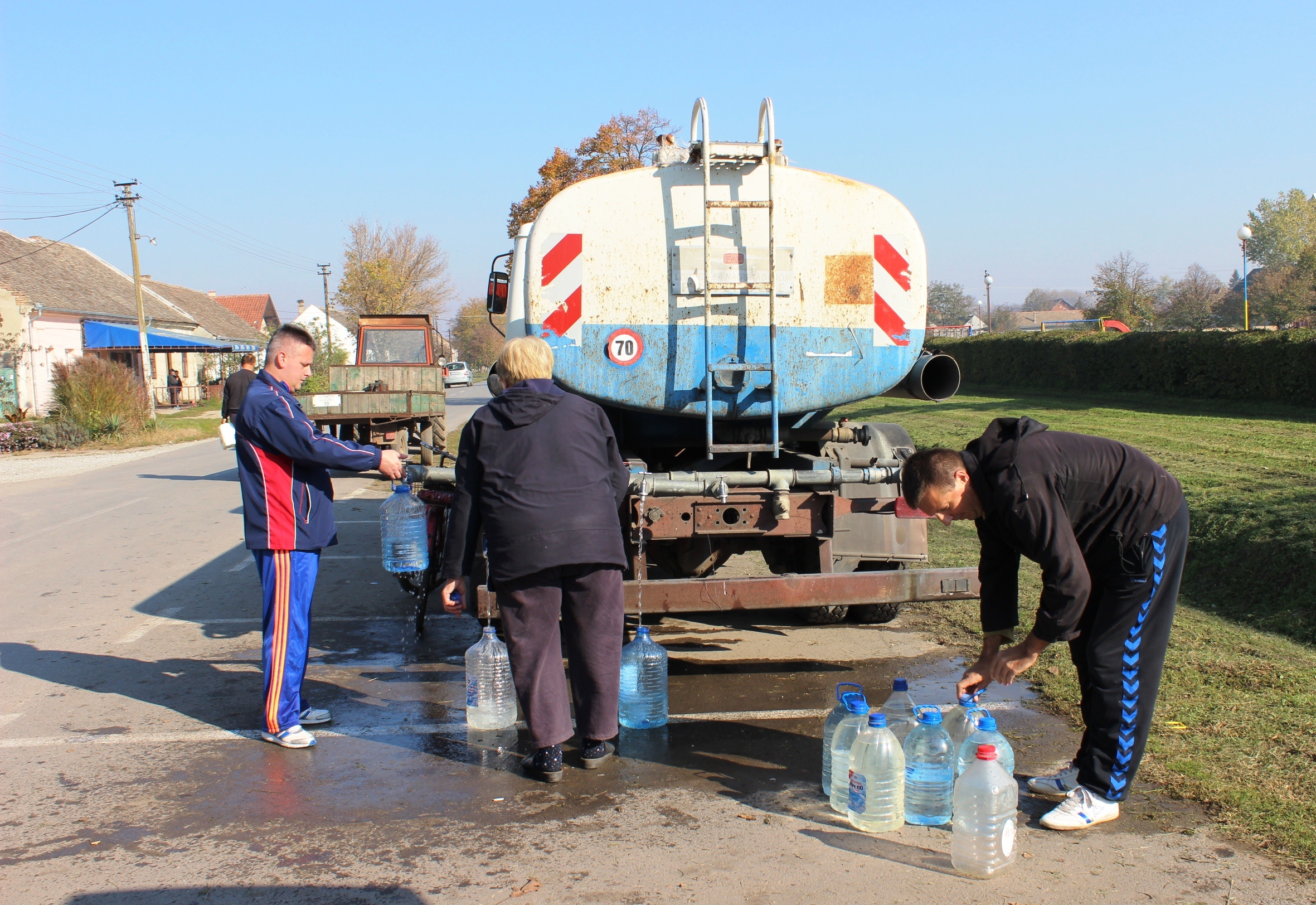 Gli abitanti di Glogonj riempiono le bottiglie dalla cisterna (foto CINS)