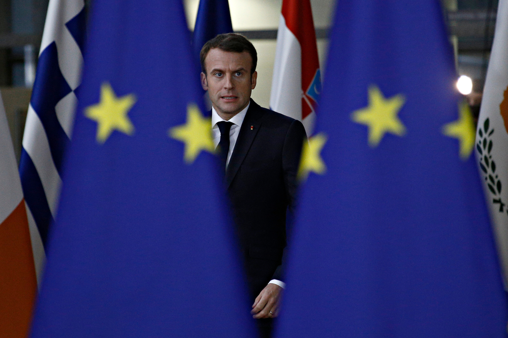 Il presidente francese Macron con davanti a lui alcune bandiere europee - © Alexandros Michailidis/Shutterstock