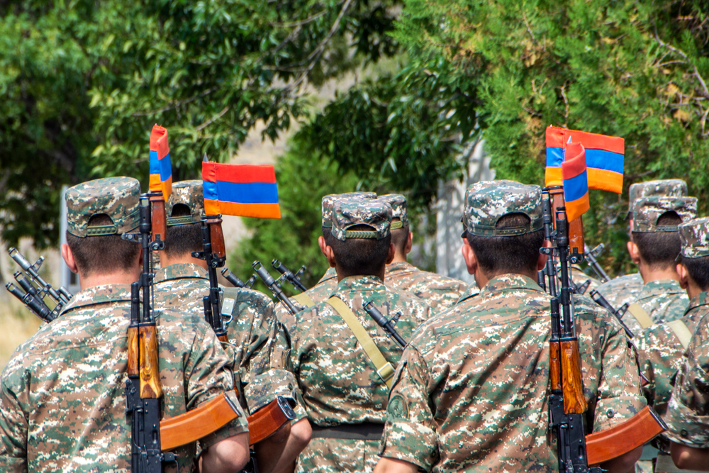 Soldati armeni fotografati di spalle con la bandiera armena infilata nella baionetta dei loro fucili - @ Artem Avetisyan/Shutterstock
