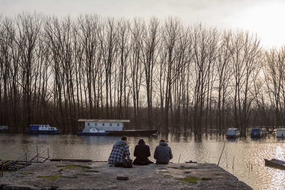Tre ragazzi seduti lungo il Danubio a Pancevo, Serbia