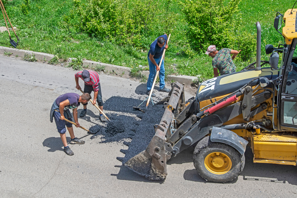 Dilijan, Armenia - May 09, 2021: Road workers repair asphalt  © Artem Avetisyan/Shutterstock
