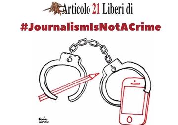 L'immagine raffigura un paio di manette che simbolicamente chiudono una matita e un telefono cellulare. Una frase sopra il disegno dice journalism is not a crime