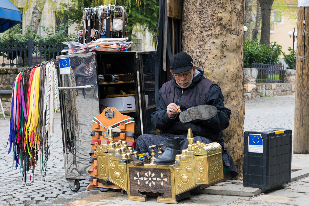 Un lucidascarpe in centro a Prizren - © dinosmichail/Shutterstock