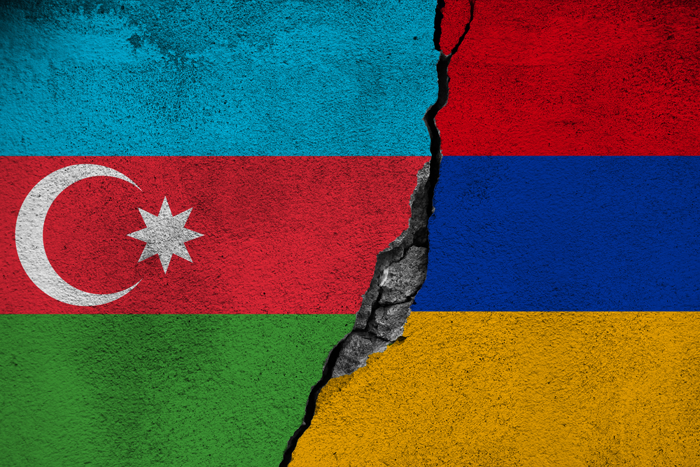 Concept of the Conflict between Armenia and Azerbaijan with painted Flags on a Wall and a Crack between them