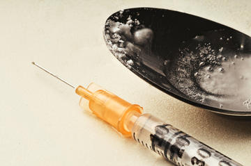 Siringa e cucchiaio per iniettarsi eroina © Leonardo.G/Shutterstock