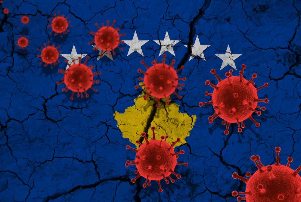 Red virus cells against the background of a cracked Kosovo flag