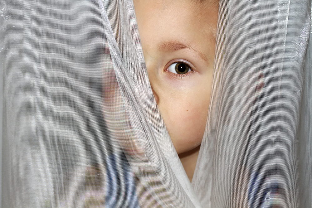 A child behind a curtain