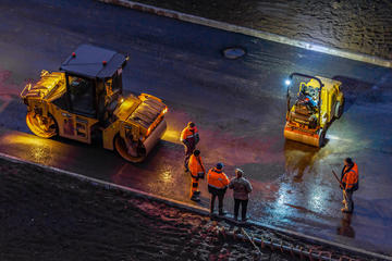 Alcuni lavoratori edili dediti all'asfaltatura di una strada  - © Evgenii Panov/Shutterstock