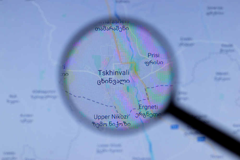 Lente di ingrandimento evidenzia sulla mappa Tskhinvali, la capitale dell'entità de facto dell'Ossezia del sud © Postmodern Studio/Shutterstock