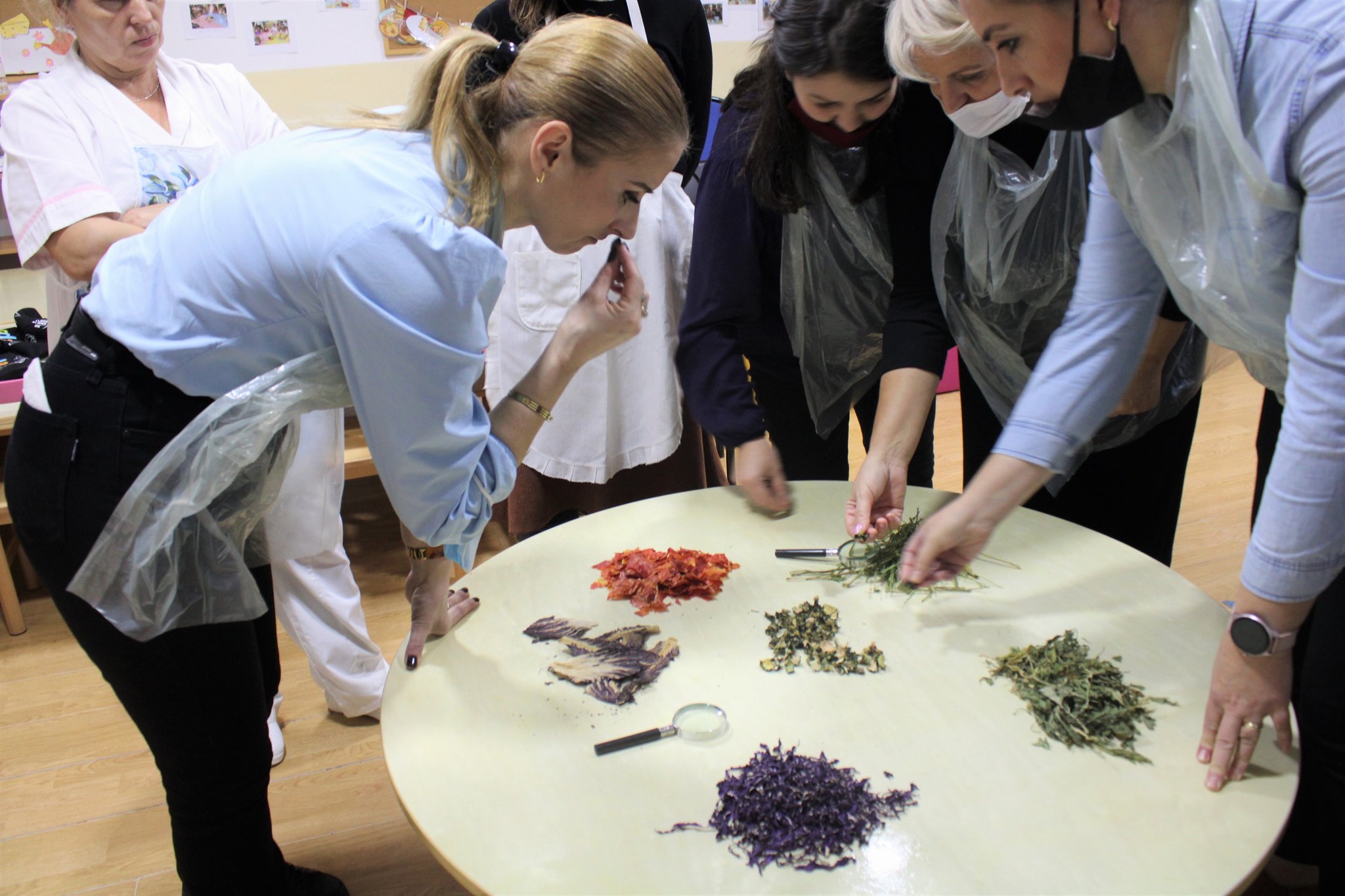 Una maestra annusa del cibo durante uno degli atelier promossi da Pause-Atelier dei Sapori in Kosovo - © RTM Volontari nel mondo