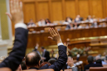 I membri del parlamento rumeno votano alzando le mani