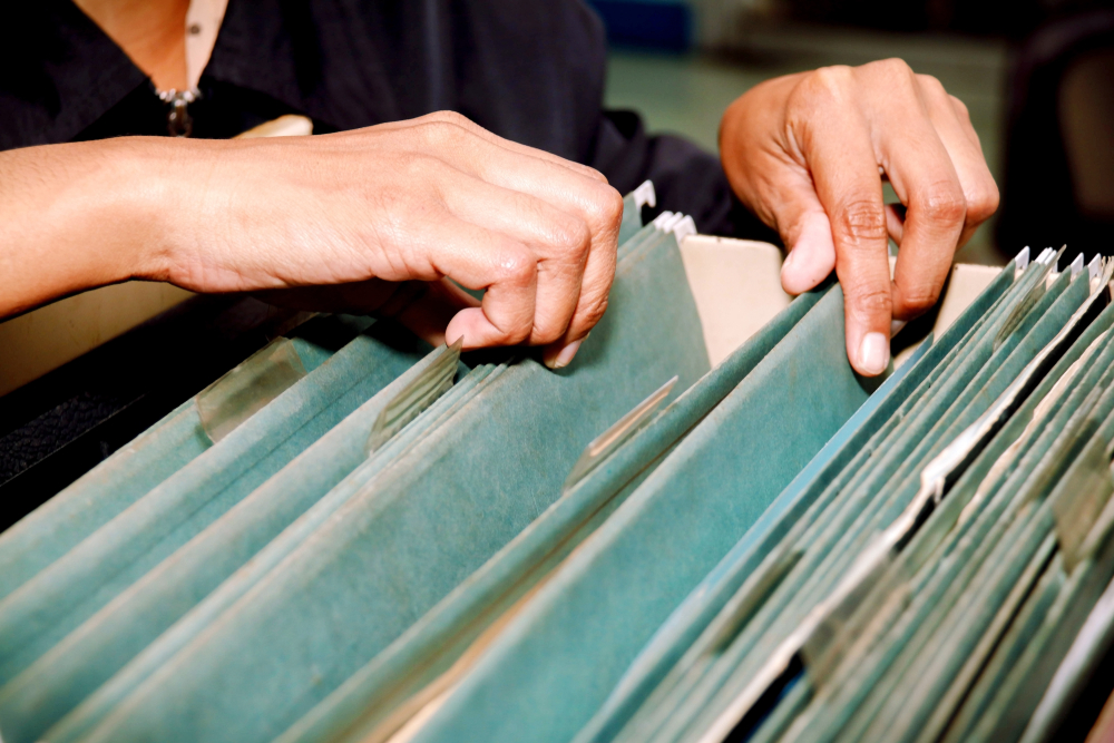 Mani di donna che cerca in un vecchio archivio © chalermphon_tiam/Shutterstock