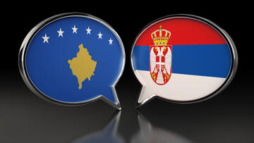 Un'illustrazione che raffigura due fumetti con le bandiere di Serbia e Kosovo
