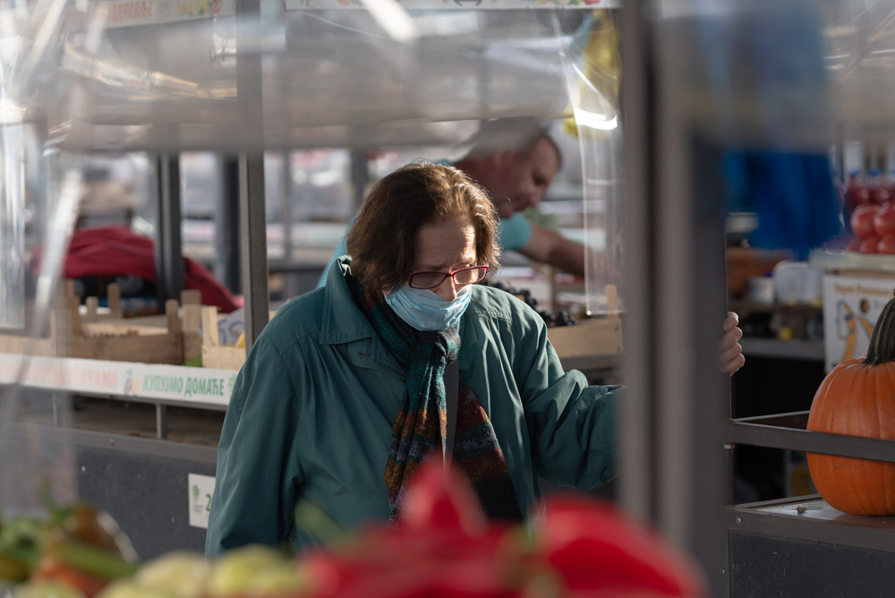 Una donna anziana con la mascherina al mercato a Belgrado (foto © Beliphotos/Shutterstock