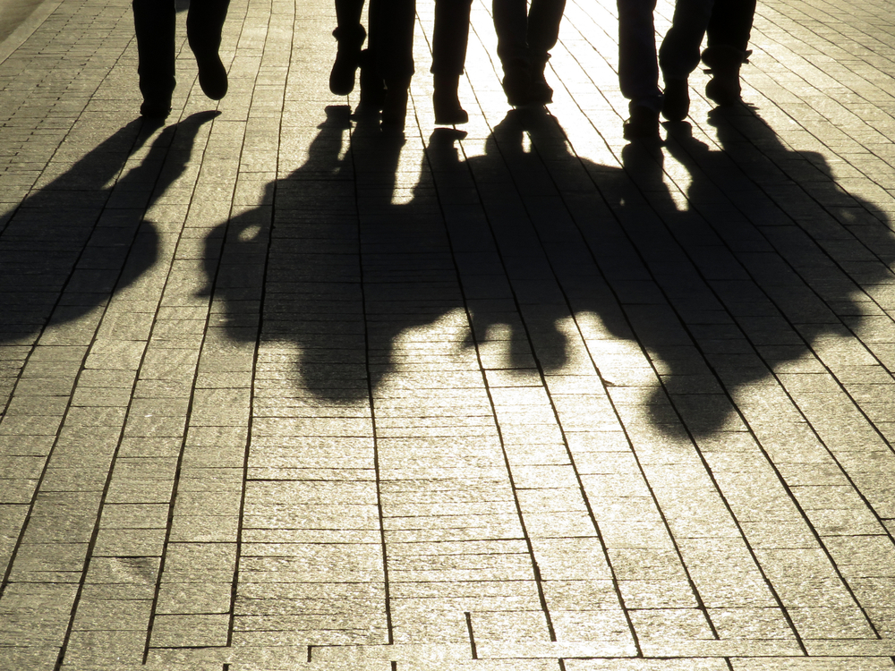 Ombre di uomini che camminano sul marciapiede (© Oleg Elkov/Shutterstock)