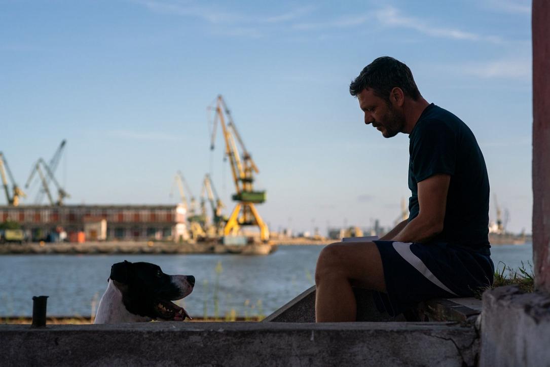Un uomo osserva un cane, immagine tratta da “Man and Dog” del romeno Stefan Constantinescu