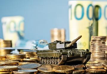 modellino di carro armato tra monete di euro