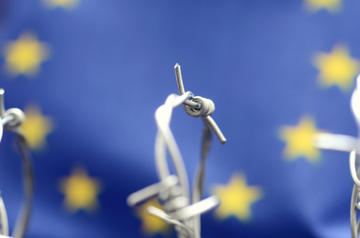 Bandiera europea e filo spinato (Corgarashu - Shutterstock ) Bandiera europea e filo spinato (Corgarashu - Shutterstock )