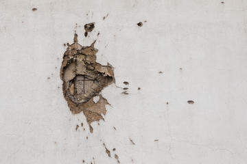 Il segno di una scheggia di mortaio su un muro di Sarajevo - © Fredy Thuerig/Shutterstock