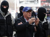 L'arresto di Ramkoski davanti alle telecamere, circondato da agenti a volto coperto (frame dal notiziario Ap)