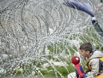 Un bambino gioca vicino alla rete che separa Grecia e Macedonia a Idomeni, 7 marzo 2016 (Foto Jordi Bernabeu Farrús, Flickr)