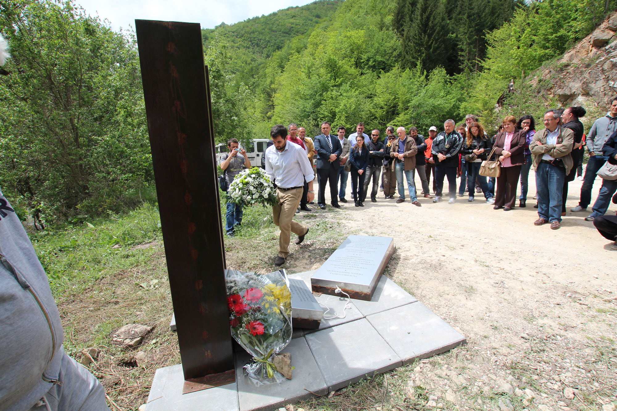 Il-rappresentante-della-Caritas-depone-una-corona-di-fiori