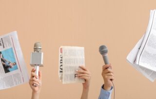 Mani con microfoni e giornali