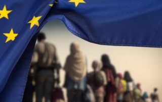 Bandiera UE e migranti © Bartolomiej Pietrzyk/Shutterstock